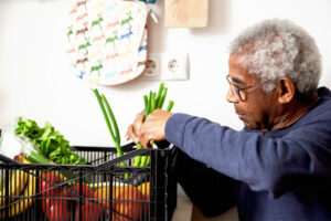 Anciano con una cesta de verduras frescas