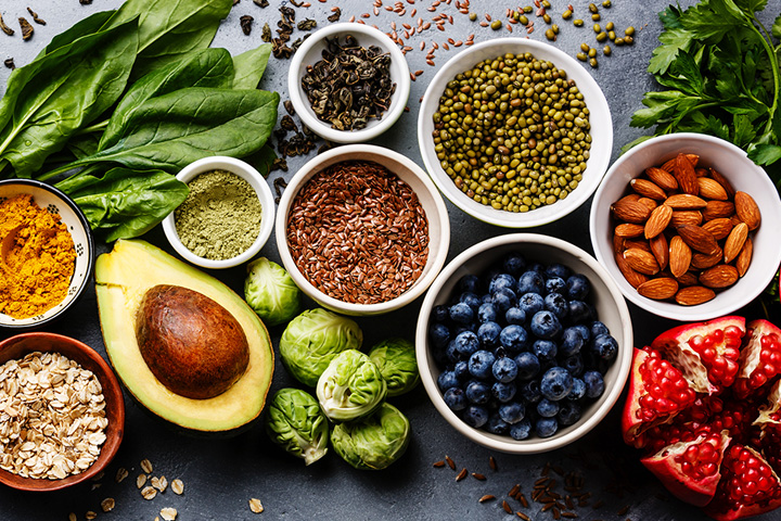 Fotografía cenital de coloridas frutas, verduras, nueces y semillas.