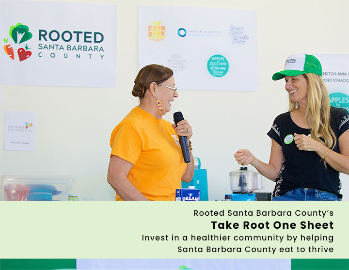 Dos oradores de Rooted dan una presentación con un texto descriptivo: "Rooted Santa Barbara County's<br />
 Hoja informativa "Toma raíces"<br />
 Invierta en una comunidad más saludable ayudando<br />
 Condado de Santa Bárbara: comer para prosperar"